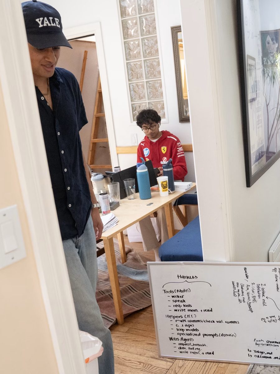 A whiteboard of architecture notes propped in the hallway beside someone working.