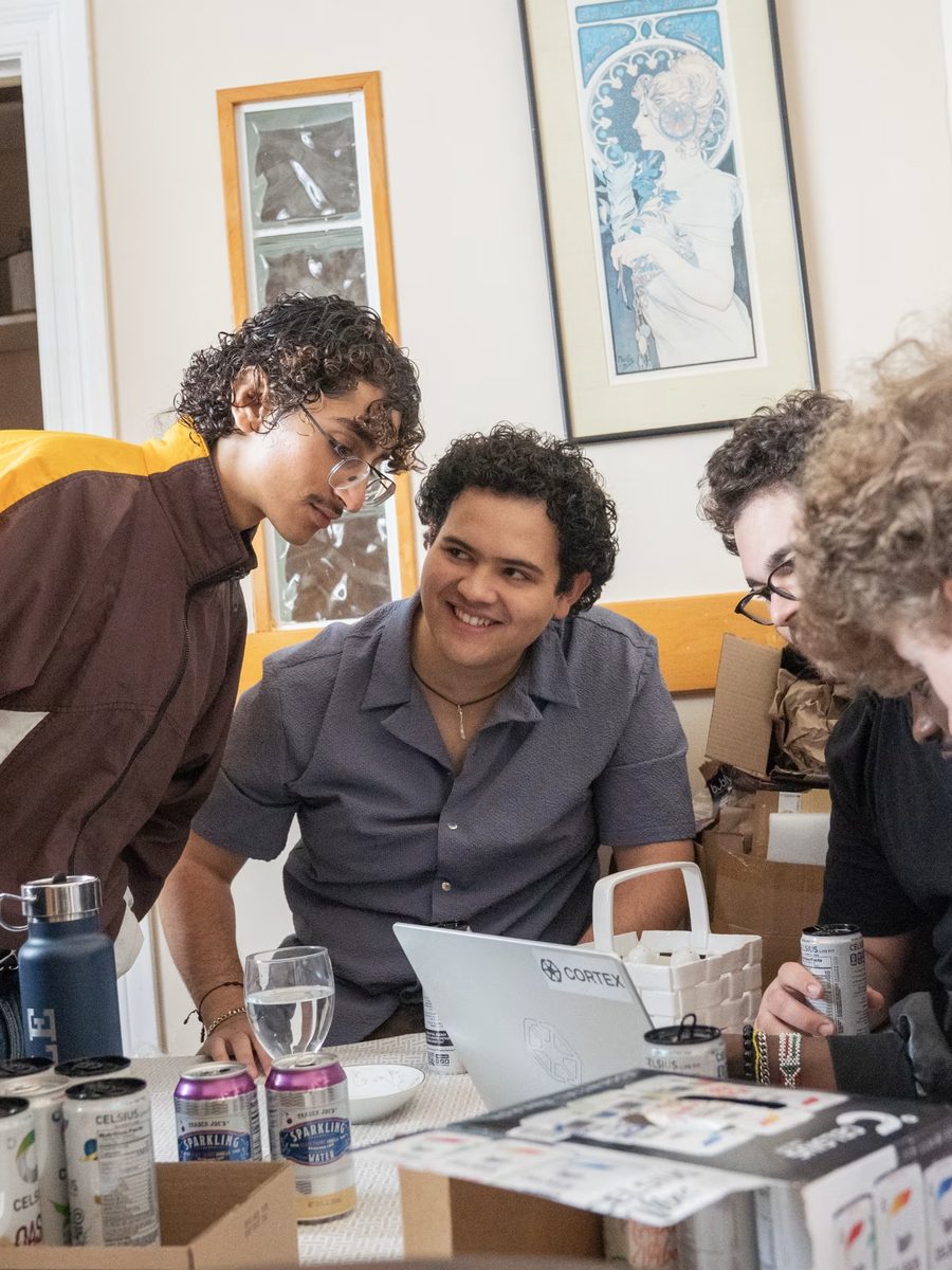 Founders gathered around a laptop at the dining table.